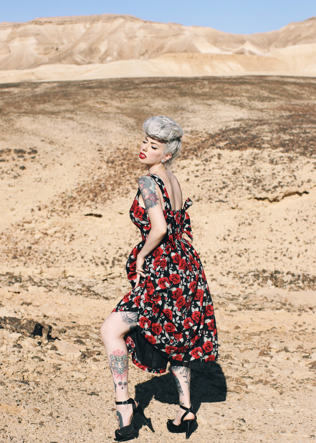 Person wearing a floral dress in a desert landscape