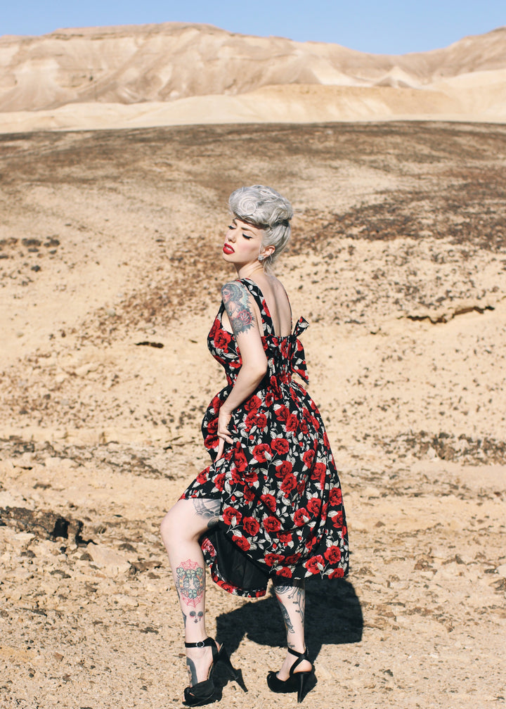 Person wearing a floral dress in a desert landscape
