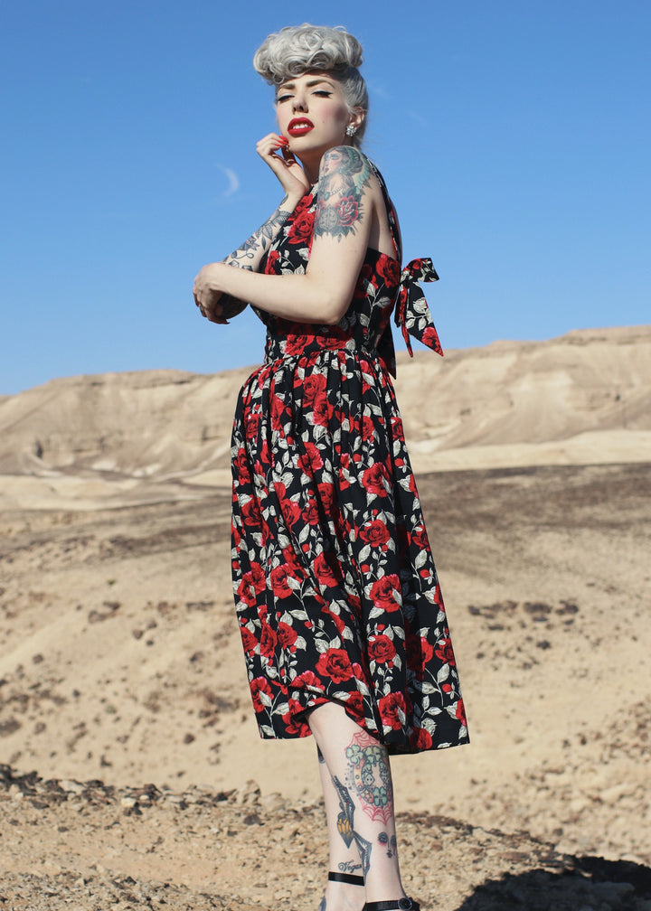 Woman in a floral dress standing in a desert landscape