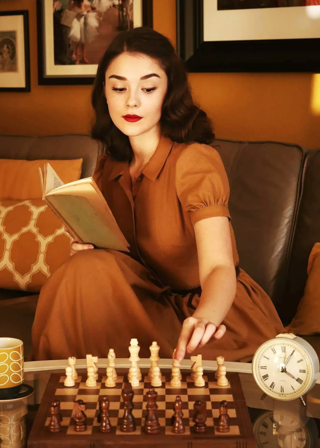 Woman in a brown dress playing chess in a cozy living room.