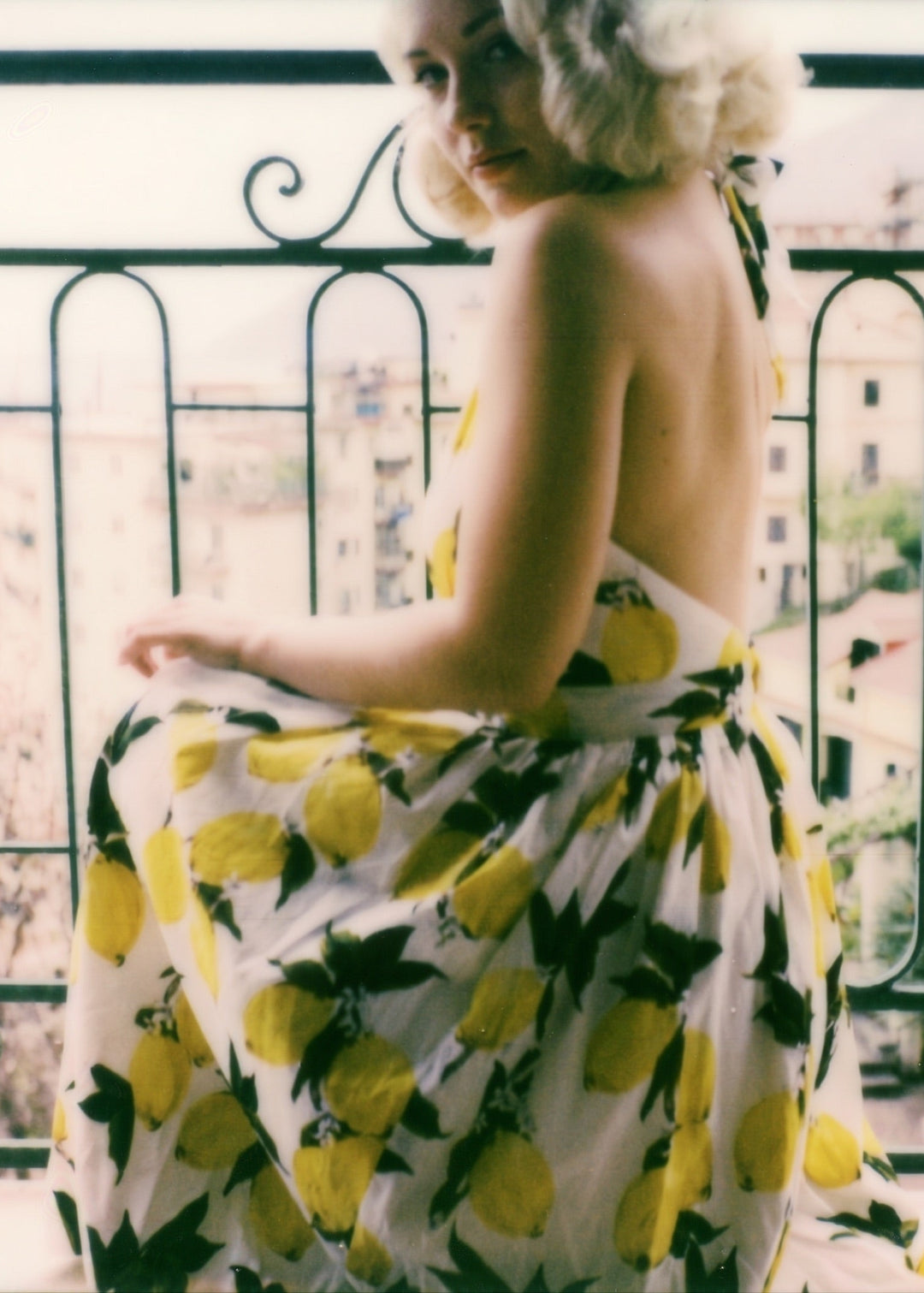 Woman wearing a dress with lemon pattern on a balcony
